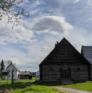 Wooden buildings on green grass in a historic village