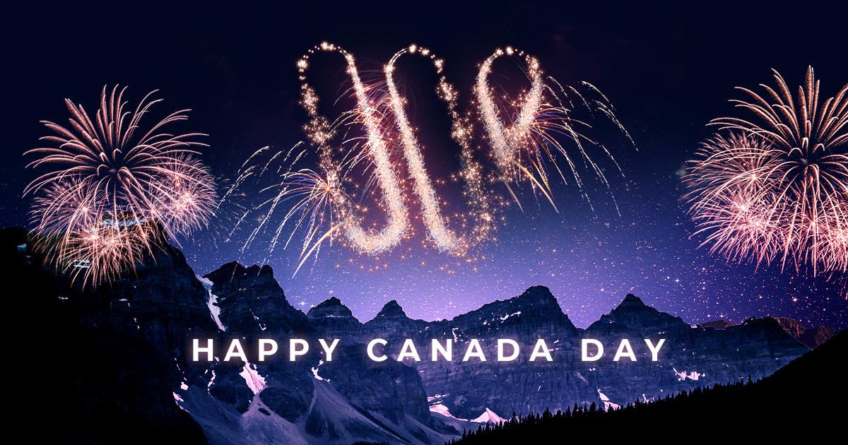 Picture of a Waypoint logo made by fireworks over a mountain range with the words "Happy Canada Day"